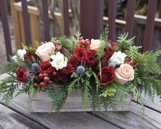 a wooden box filled with flowers and greenery