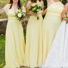 four bridesmaids in yellow dresses posing for the camera