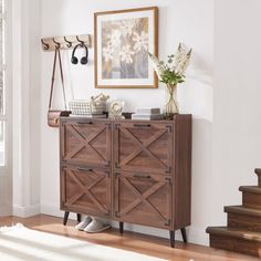 a wooden cabinet sitting on top of a hard wood floor next to a stair case