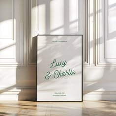 a poster on the floor in front of a white wall with green lettering that reads, lucky & charlie