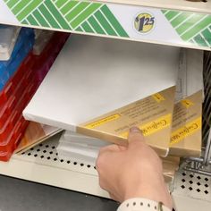 a person picking up some boxes from the shelf