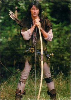 a man dressed in costume holding a bow and arrow