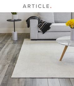 a living room with white furniture and wood flooring is featured in the article article