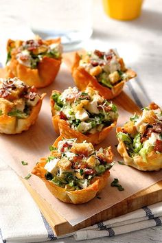 small appetizers are sitting on a cutting board