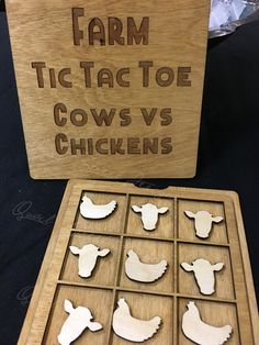 a wooden box with cutouts of farm animals and words on the lid that says, farm tic tact toe cows vs chickens