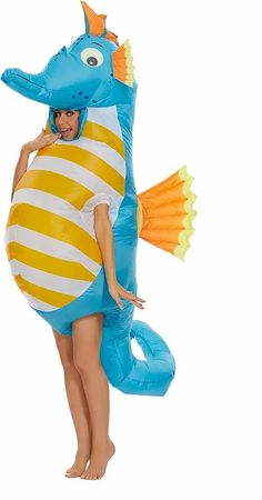 a woman in a blue and yellow costume is holding an inflatable seahorse