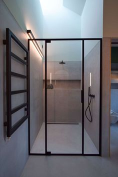 a bathroom with a glass shower door and two lights on the wall next to it