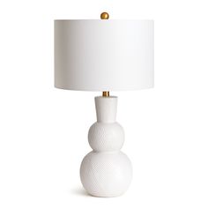 a white lamp sitting on top of a table next to a white lampshade