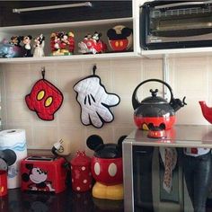 a kitchen with mickey mouse magnets on the wall and other disney themed items in front of it