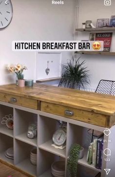 the kitchen breakfast bar is made out of wood and has shelves with clocks on them