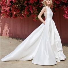 a woman in a white wedding dress standing next to flowers