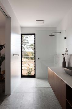 a bathroom with a sink, mirror and large window in it's side wall