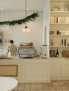 a woman standing at the counter in a kitchen