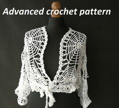 a white crochet shawl on top of a black mannequin head