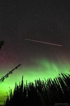 an airplane flying in the night sky with green and red lights on it's side