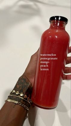 a hand holding a red bottle that says watermelon pomegranate peach lemon