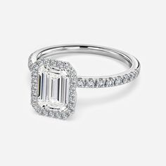 an emerald cut diamond ring with pave set shoulders