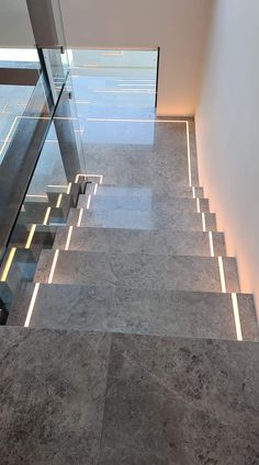 the stairs are made of marble and have glass railings that lead up to them