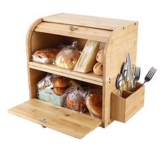 a wooden counter with bread and utensils in it