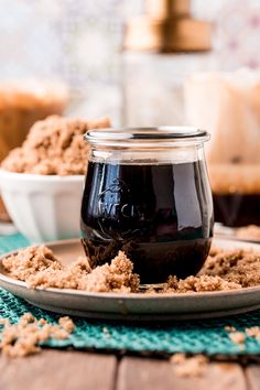 a glass jar filled with liquid sitting on top of a plate next to another bowl