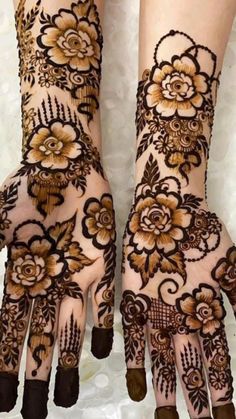 two hands with henna designs on them