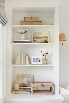 a white shelf filled with books and pictures