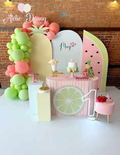 a table set up for a party with balloons and decorations on it, including a lemon slice