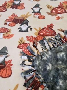 a close up of a table cloth with birds and pumpkins on it, as well as an ironing board