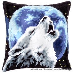 a cross stitch pillow with a white wolf on it's face and the moon in the background