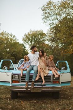 a family sitting on the back of a pickup truck