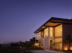 a modern house with lights on at night