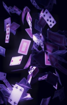 playing cards are falling into the air on a black background with pink and purple colors