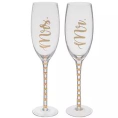 two champagne glasses with gold lettering on them