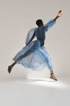 a woman in a blue dress is dancing