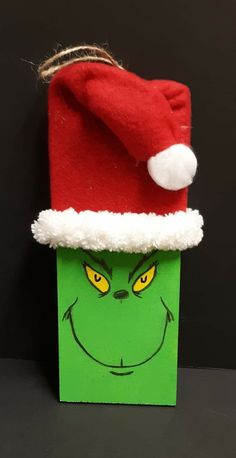 an elf's hat on top of a green bag with yellow eyes and nose