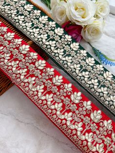 two red and green sashes with white flowers on them sitting next to each other