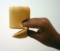 a hand holding a piece of yellow material