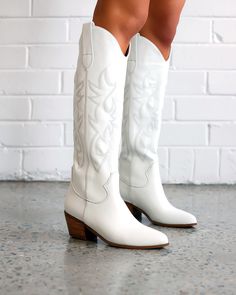 White cowboy boots are our favorite staple for this time of year! The Cowgirl Up Boot is a long, western inspired boot, + a crowd standout. Featuring; low stacked block wide fit long boot upper western inspired embroider almond toe shape oversized side pull tabs for a pull on design synthetic upper, lining + outsole Heel height 5.5cm. true to size Knee High Western Boots, Tall Western Boot, White Cowgirl Boots, White Cowboy Boots, Taupe Heels, Boot Stand, Embroidered Boots, White Boots, Long Boots