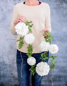 a woman is holding some flowers in her hands