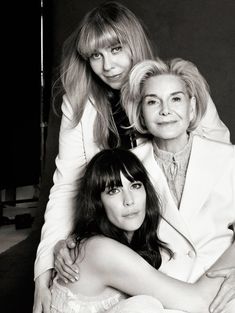 two women sitting next to each other in front of a black and white photo with one woman