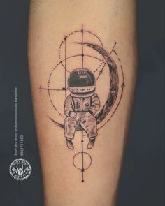 an astronaut tattoo on the leg