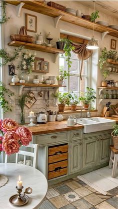 a kitchen filled with lots of greenery next to a window