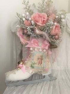 a pair of white boots with pink flowers in them on a shelf next to a dress