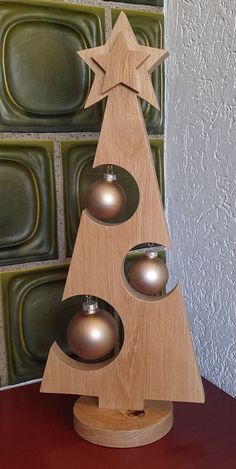 a wooden christmas tree with three silver balls