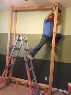 a man climbing up the side of a ladder on top of a green and white striped wall