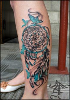 a woman's leg with a tattoo on it and a blue dream catcher in the center