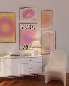 a white chair sitting in front of a dresser next to a lamp and pictures on the wall