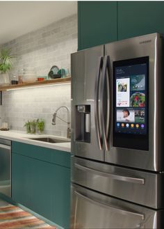 a kitchen with green cabinets and stainless steel appliances, including an appliance on the wall