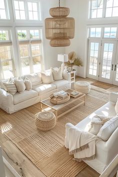 a living room filled with lots of white furniture and large window covered in wicker