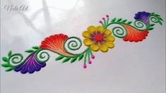 an embroidered design with colorful flowers and swirls on the side of a white surface